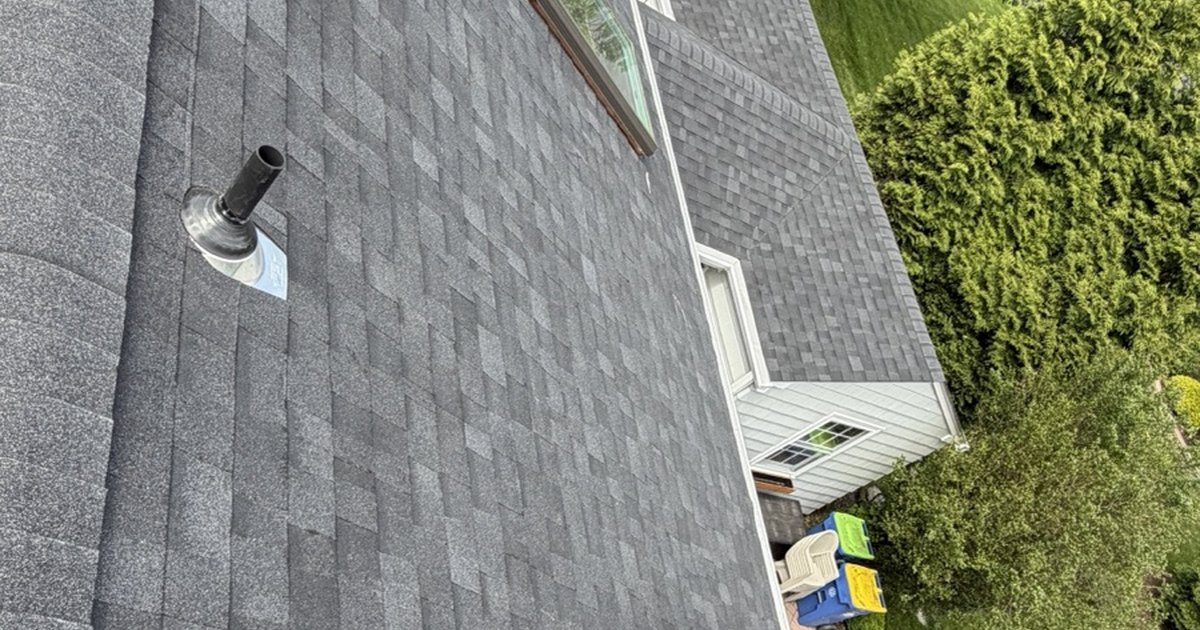Pipe vent boot and a skylight on a gray asphalt shingle roof