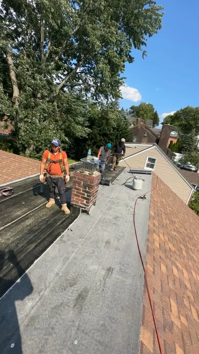 Mason taking a chimney stack down to sound brick on a Clifton NJ roof